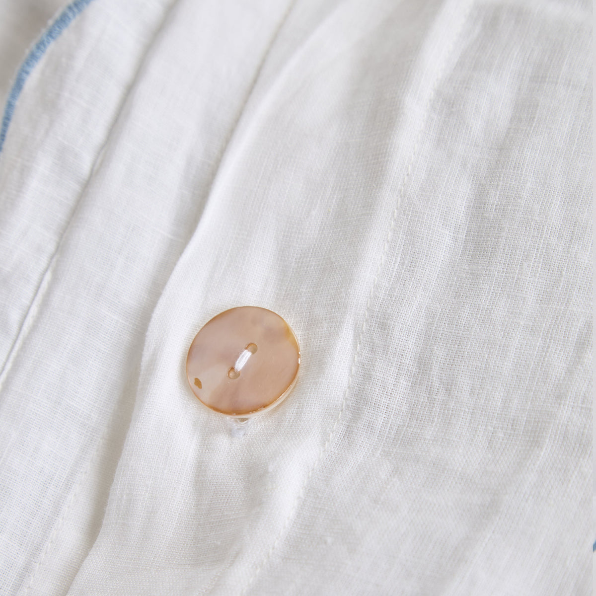 White duvet cover with blue scalloped trim and round button