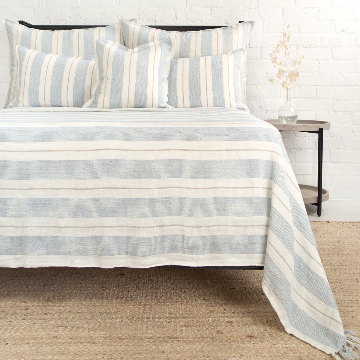 Striped blanket with fringe edge, grey and natural, on bed