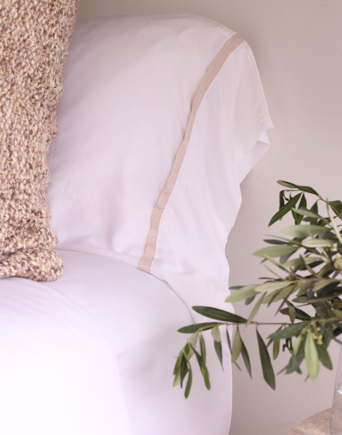 White bamboo sateen pillowcase with tan stripe trim along the edge