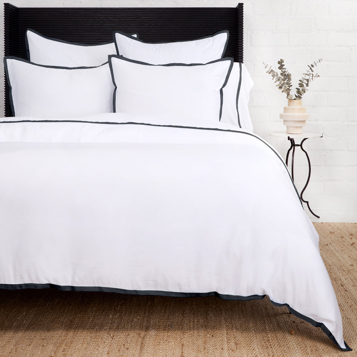 Bamboo sateen duvet cover set in white with navy piped trim and matching shams