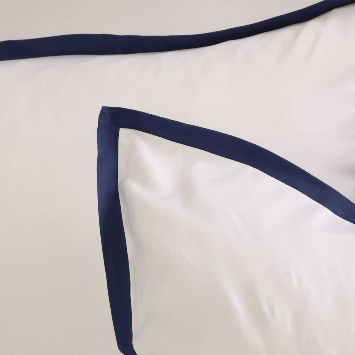 White duvet with navy contrast piping along the corner edge