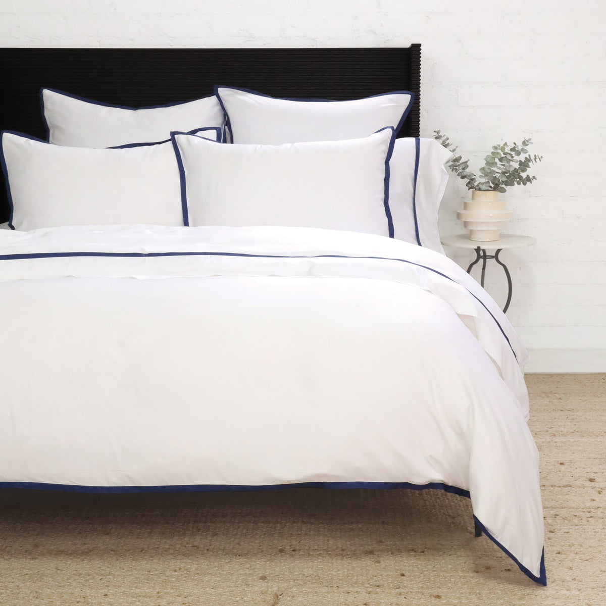 White duvet cover set with navy border piping and matching pillow shams