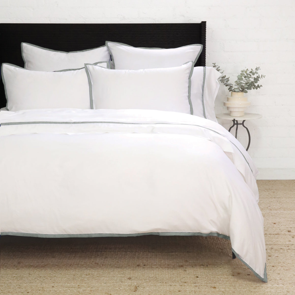 White duvet cover with navy piping and layered pillow shams