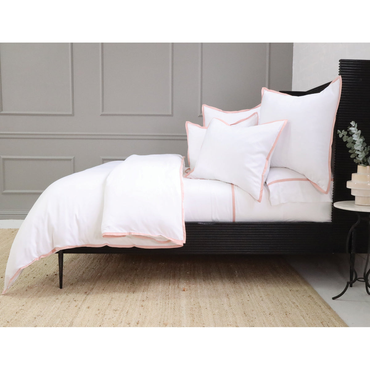 White duvet cover set with pink piping trim on shams and duvet edges