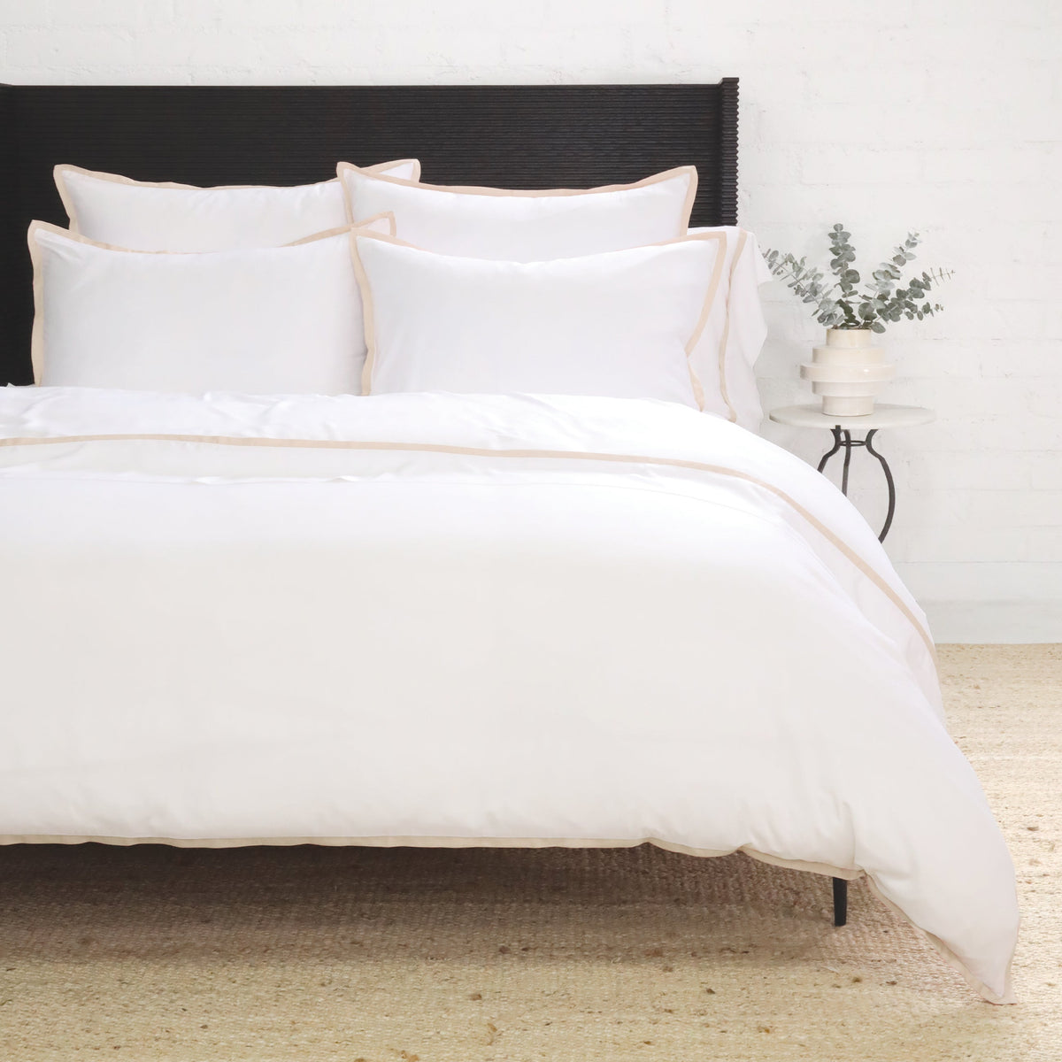 White duvet cover set with blush-pink piping along the duvet edges