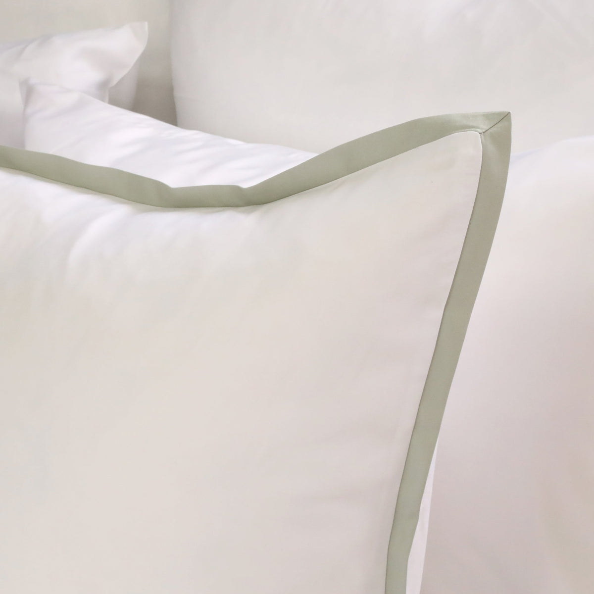 White duvet cover sham with sage green border trim and crisp corner
