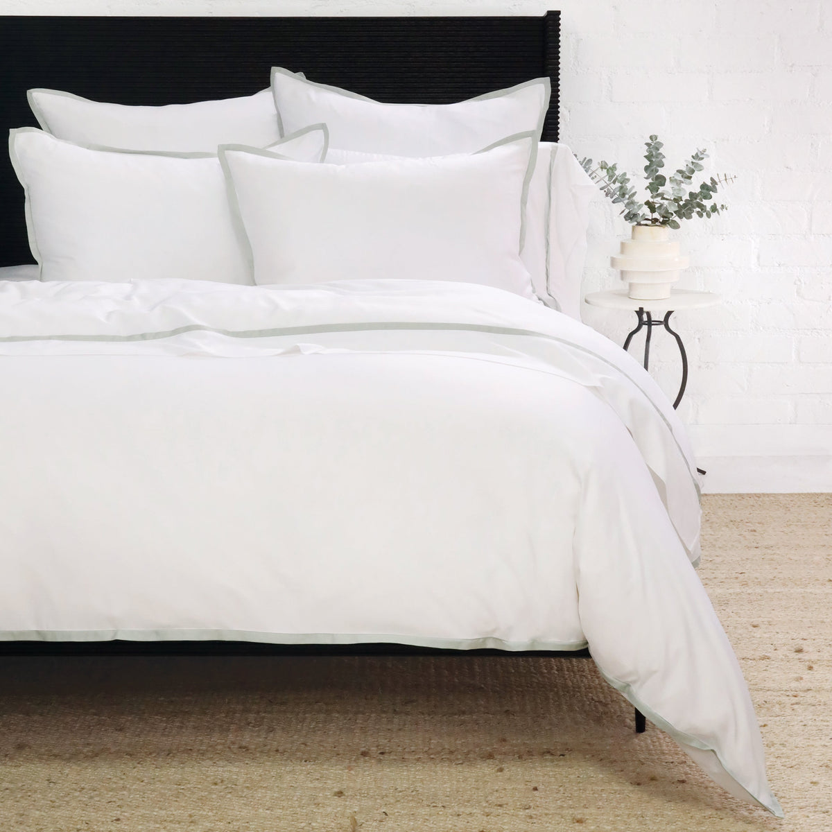 White duvet cover set with navy piping and neatly arranged shams