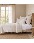 Matelasse quilt and pillow shams bedding set in light oatmeal on a bed