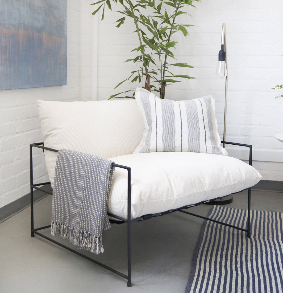 Gray and natural striped throw pillow with horizontal lines and fringed trim