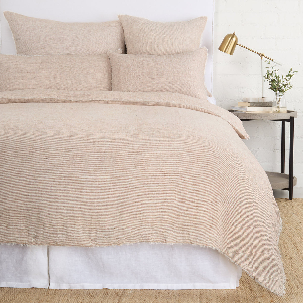 Light beige textured duvet cover with matching pillows and soft fringe trim