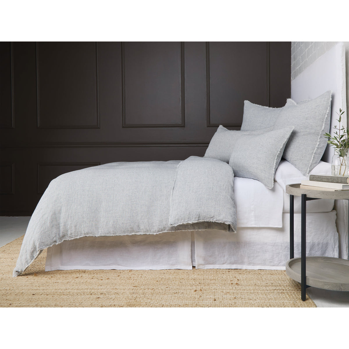Light gray textured duvet cover with fringed edge and matching pillow shams