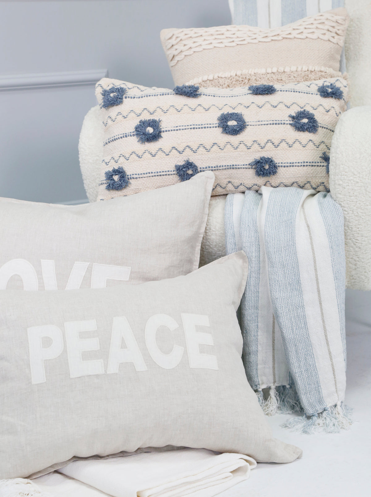 Laguna throw with white base, blue geometric motifs, and fringed striped edge