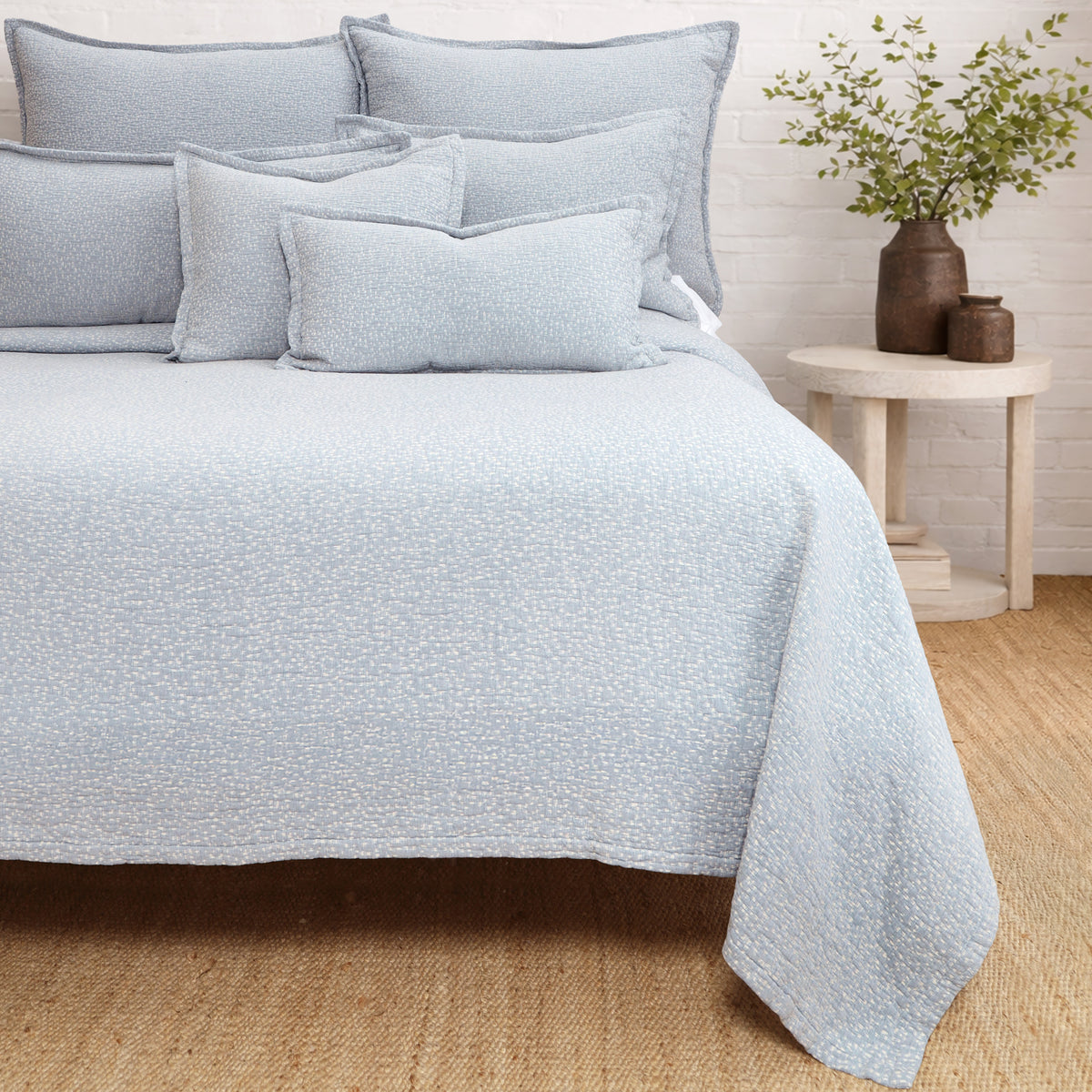 Light blue matelasse quilt with matching pillow shams and textured surface