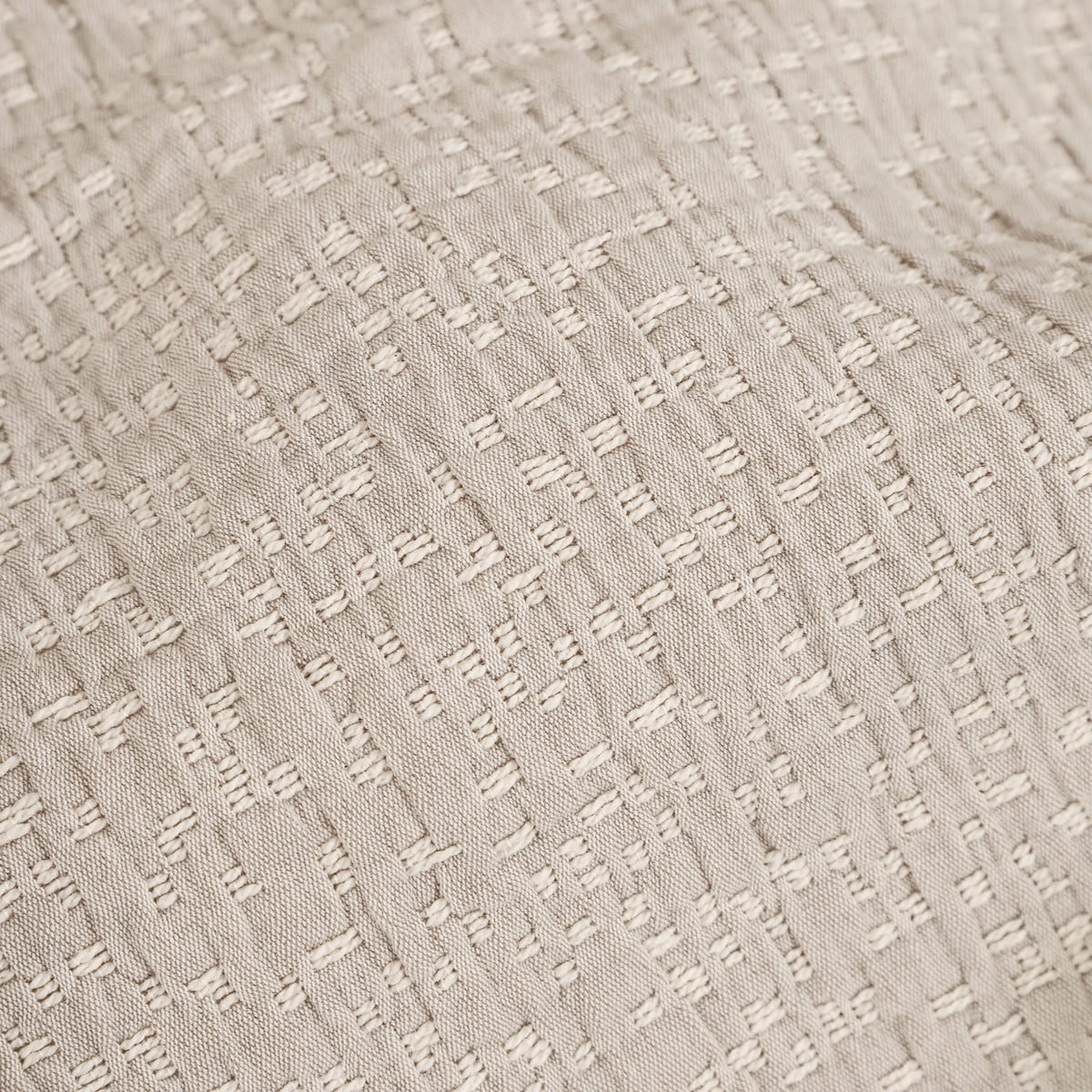 Oatmeal matelasse textured fabric swatch with raised geometric stitch pattern
