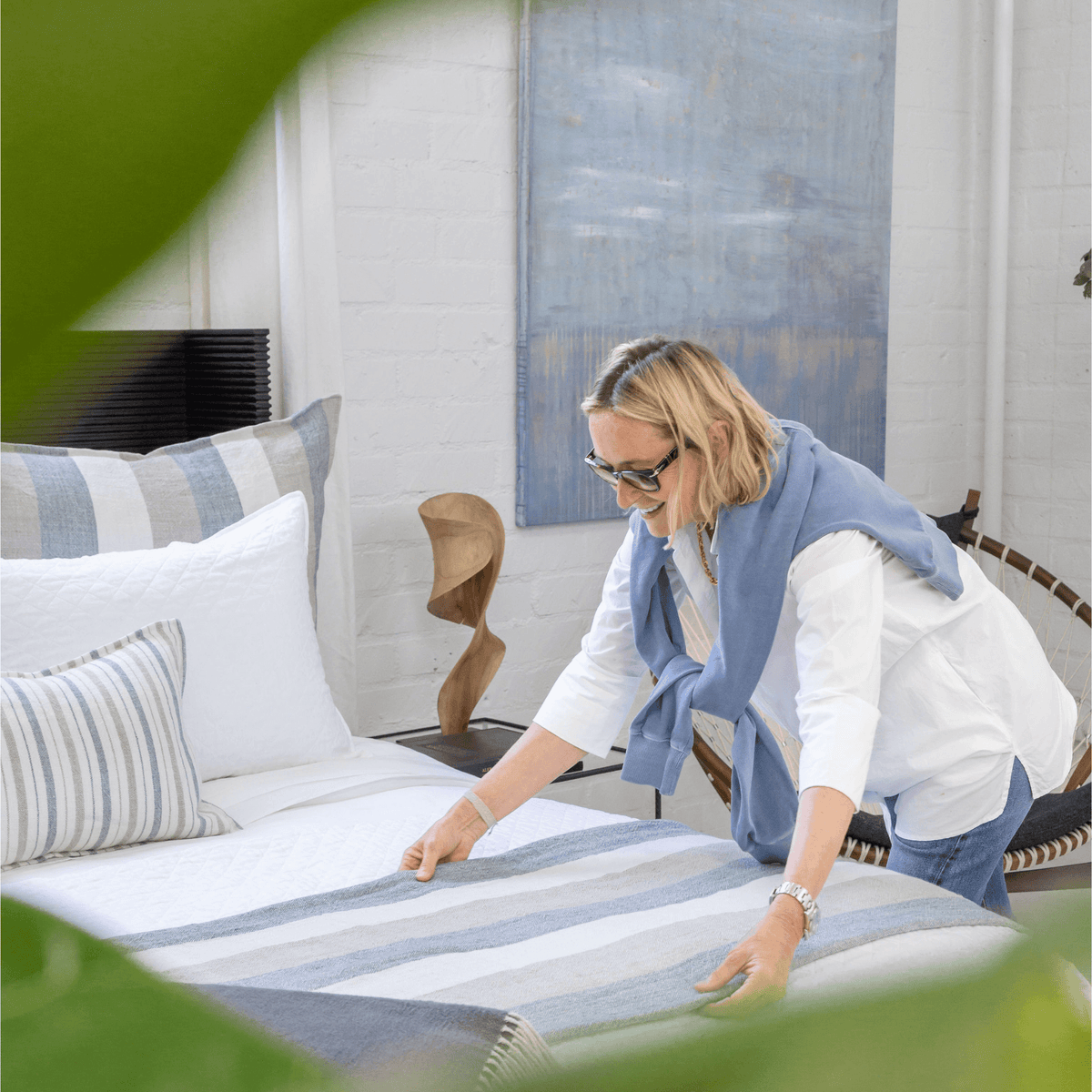 Striped blanket on bed with blue and white bands, styled in a home setting