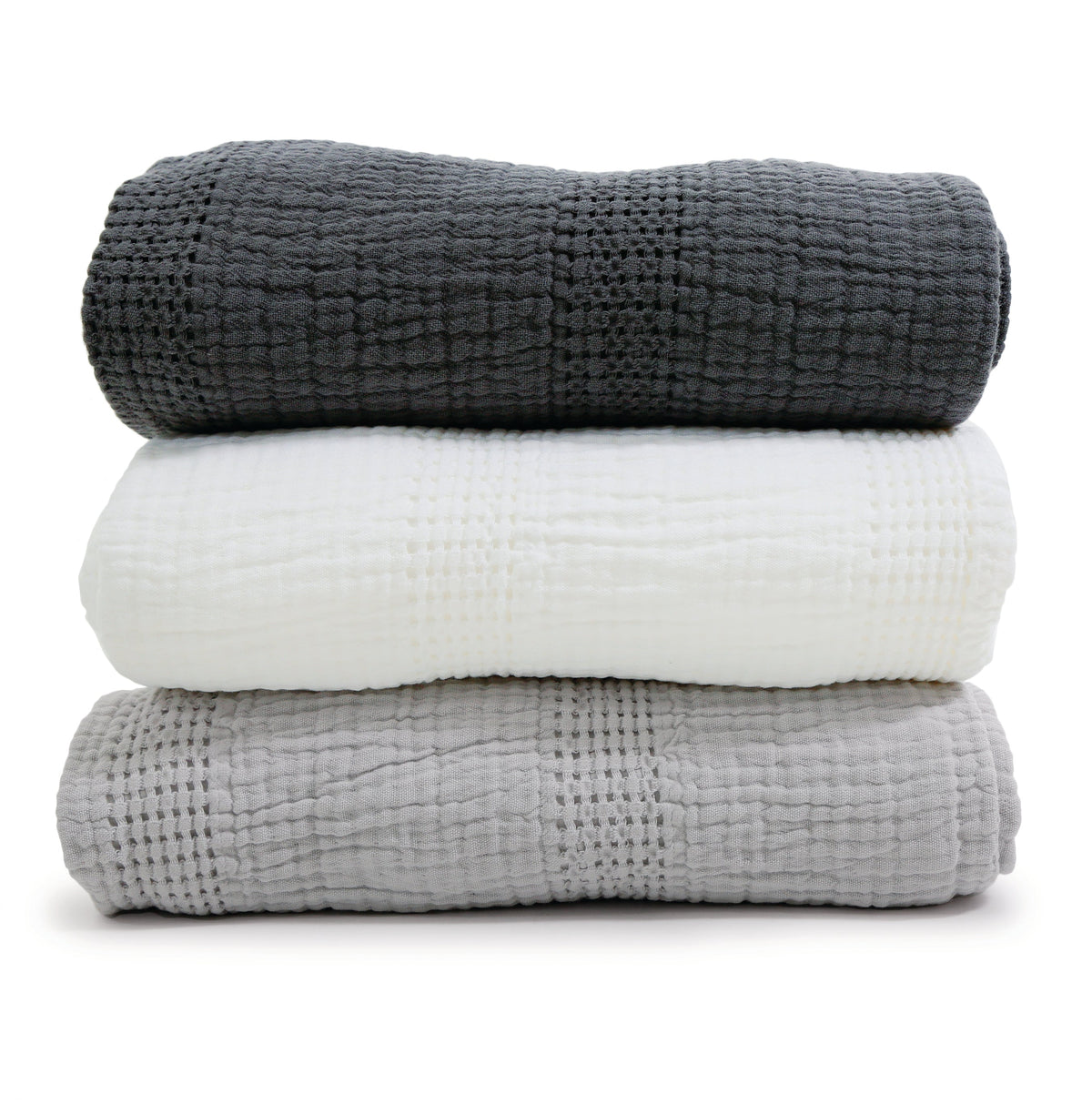 Stack of oversized throw blankets in dark charcoal, light grey, and white