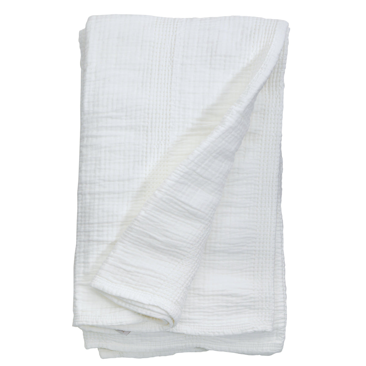 White waffle-knit oversized throw blanket, neatly folded with textured grid pattern