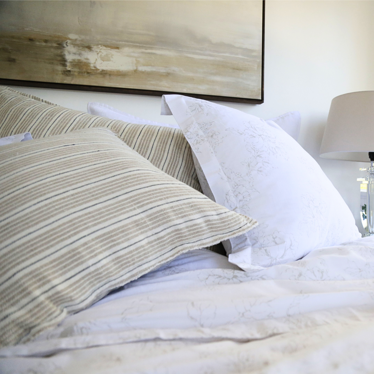 Striped square pillow with insert on bed, light gray and beige vertical lines