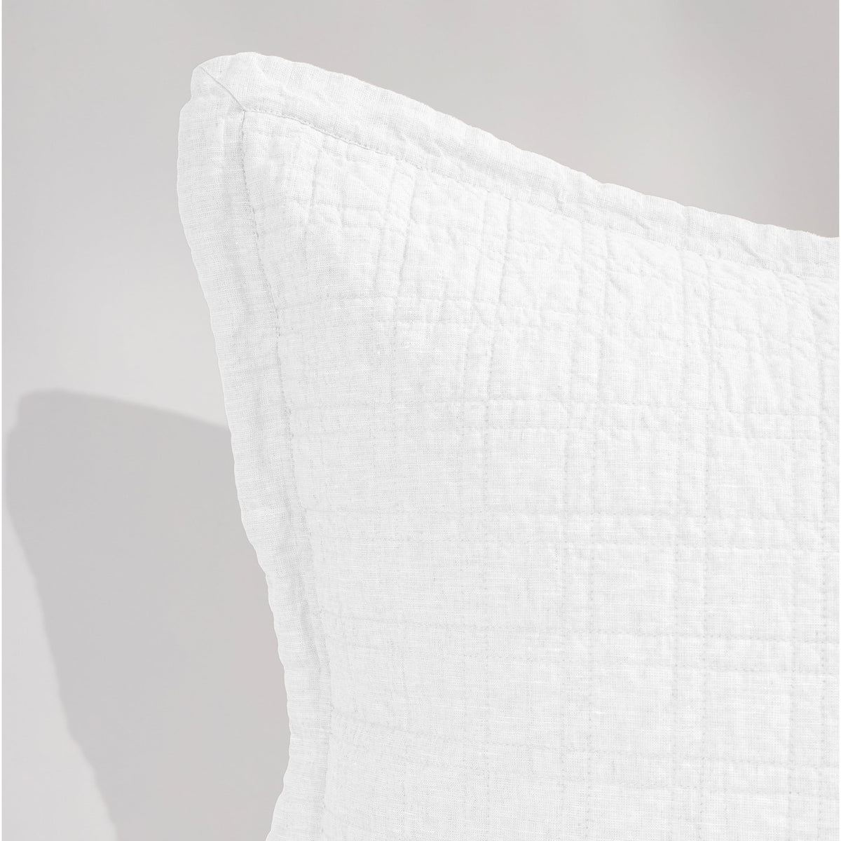 Owen coverlet in white with close-up grid quilting texture on the corner