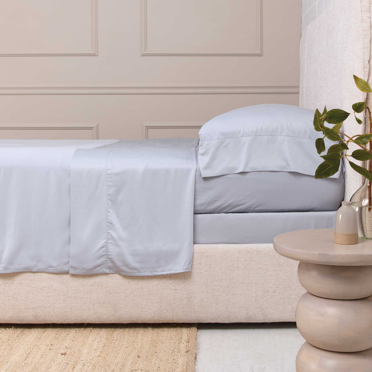 Light blue bamboo sateen sheet set on a bed, with fitted sheet and pillowcases