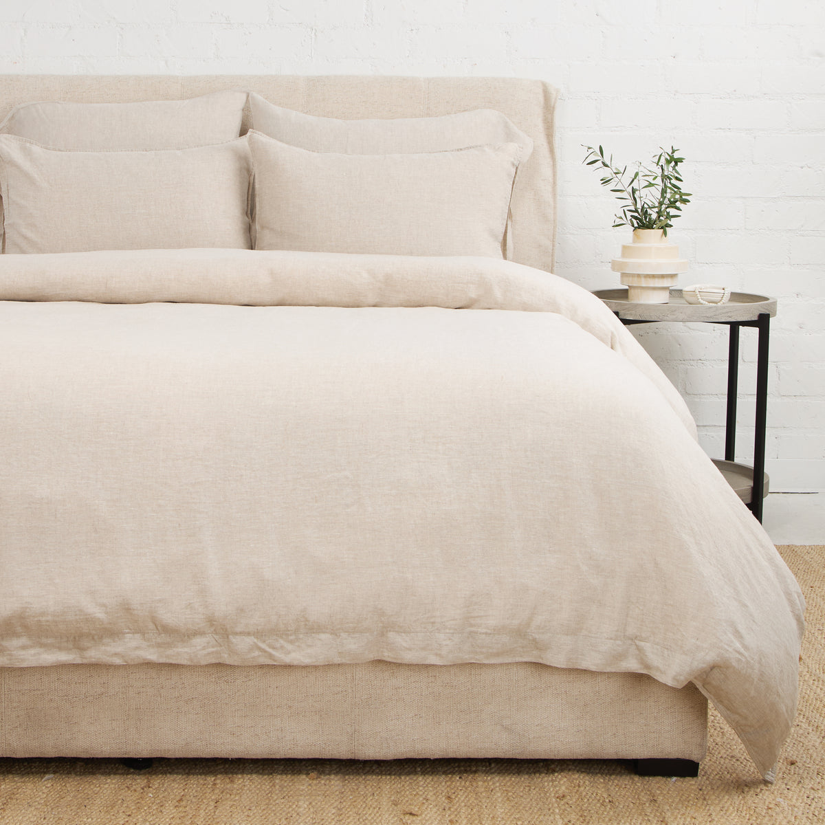 Cream linen duvet set with two pillows and duvet, neatly draped on a bed