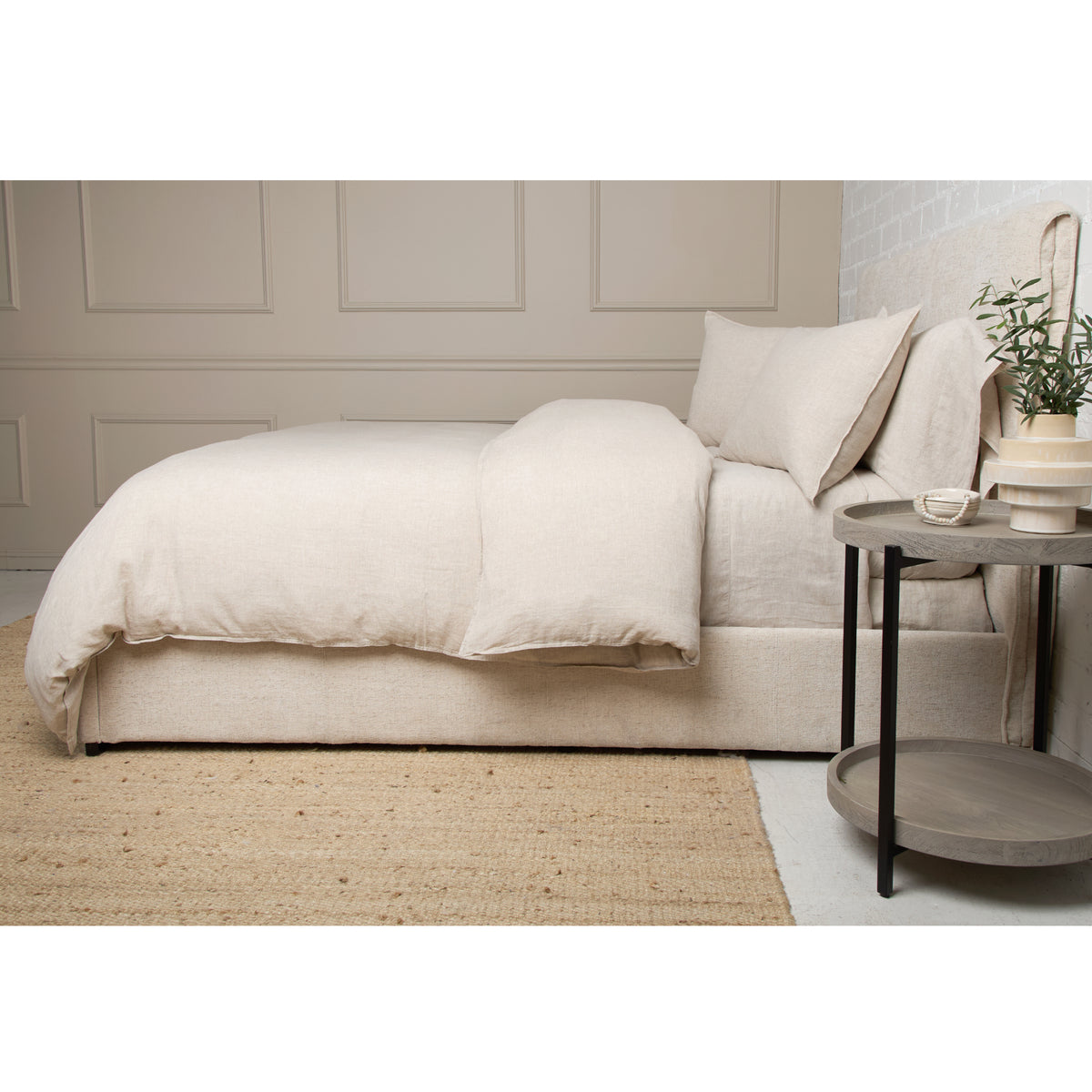 White linen duvet set with folded duvet and pillow shams in a bedroom