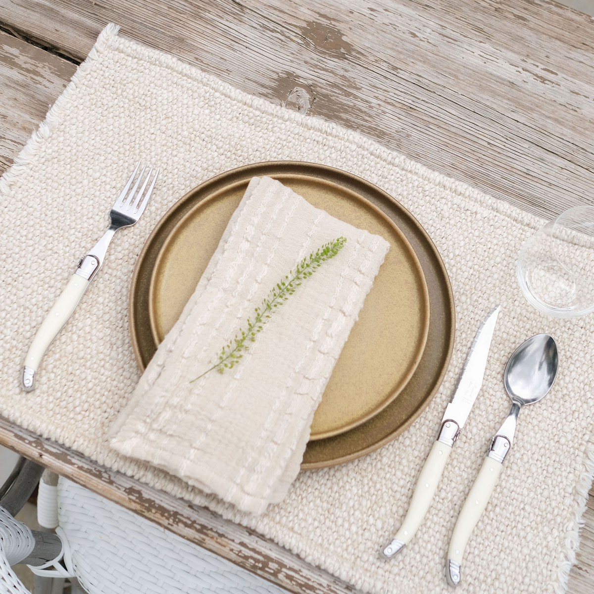 Natural woven placemat with textured surface and fringe edges