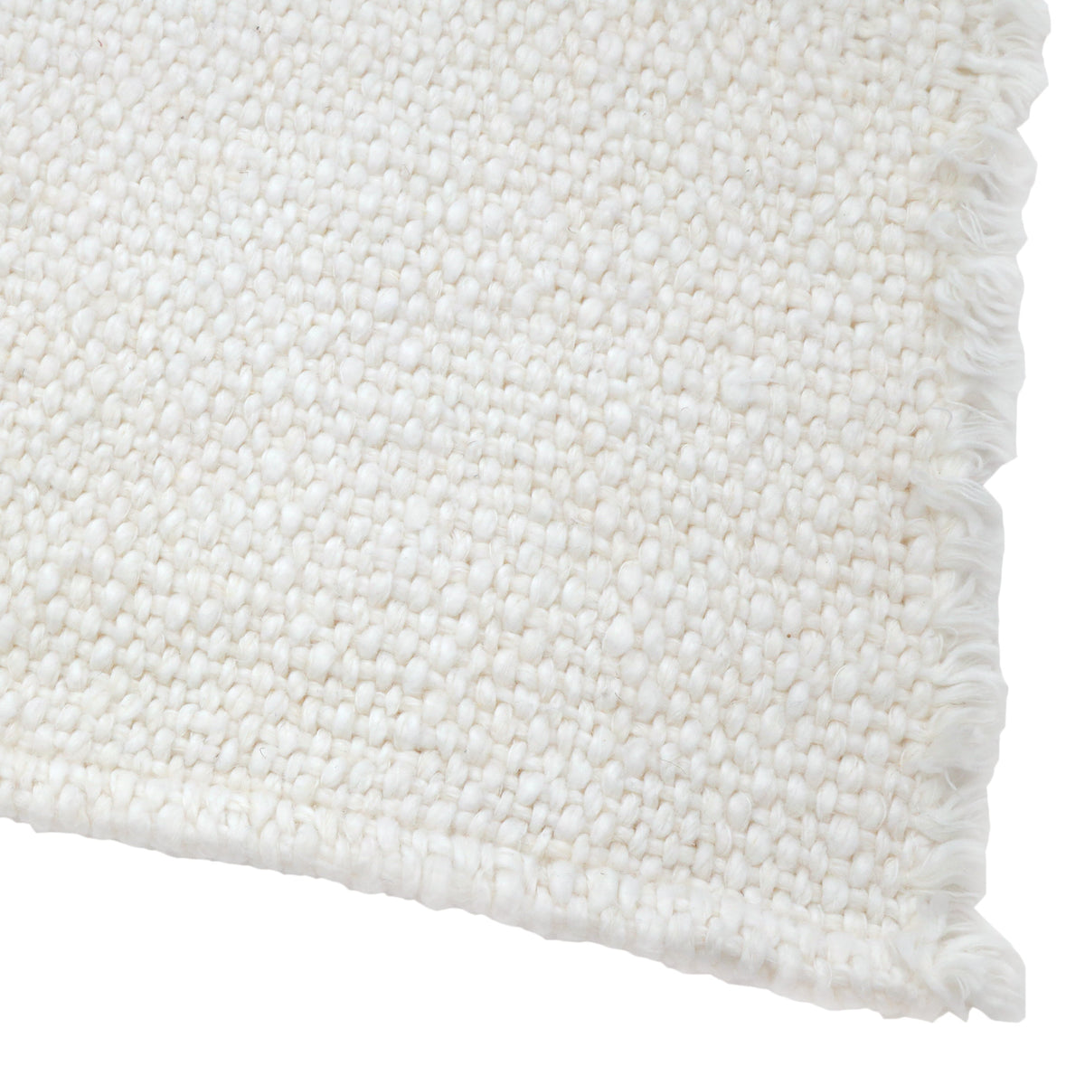 White placemat close-up with woven texture and fringed border