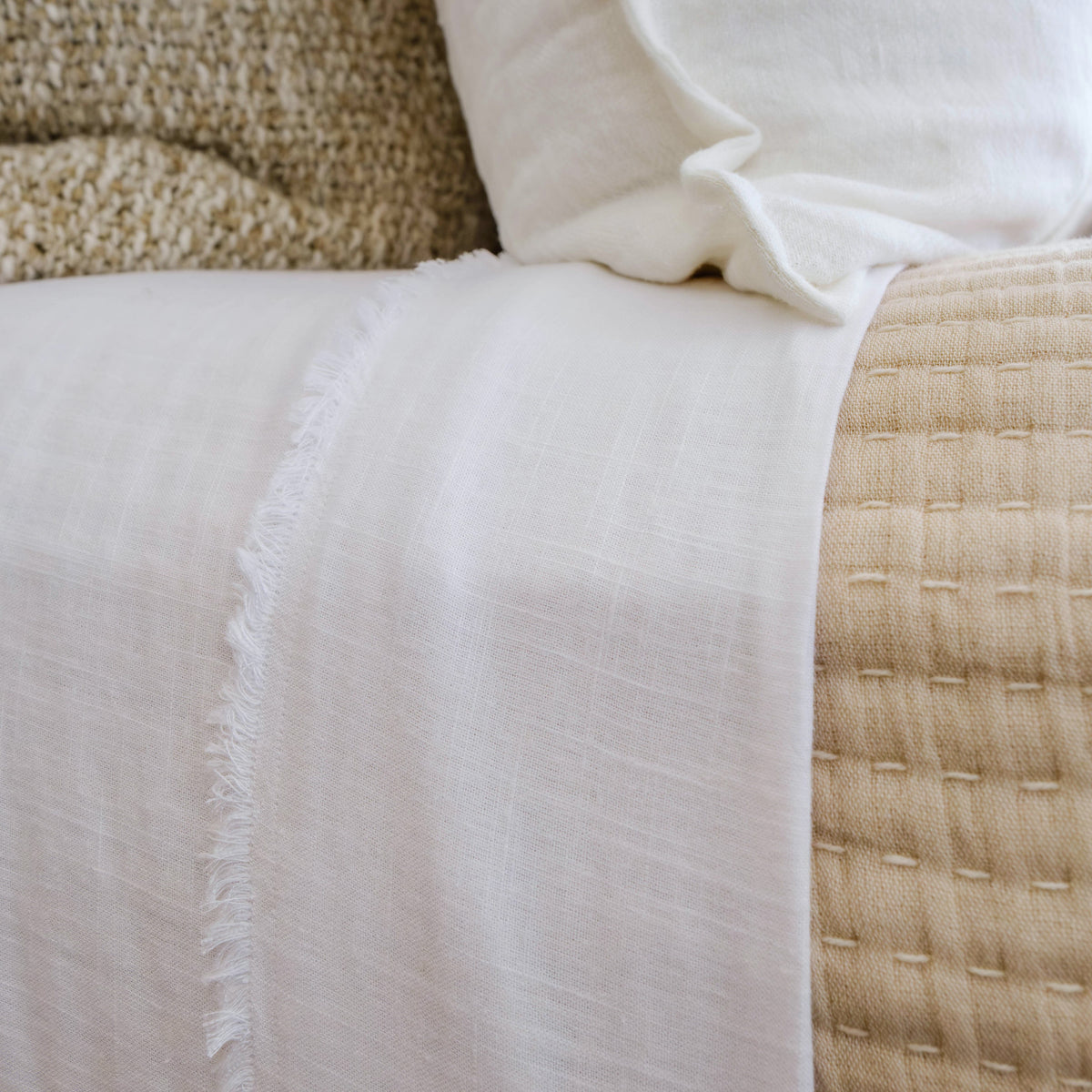 Bamboo linen sheet edge close-up with textured weave and frayed trim
