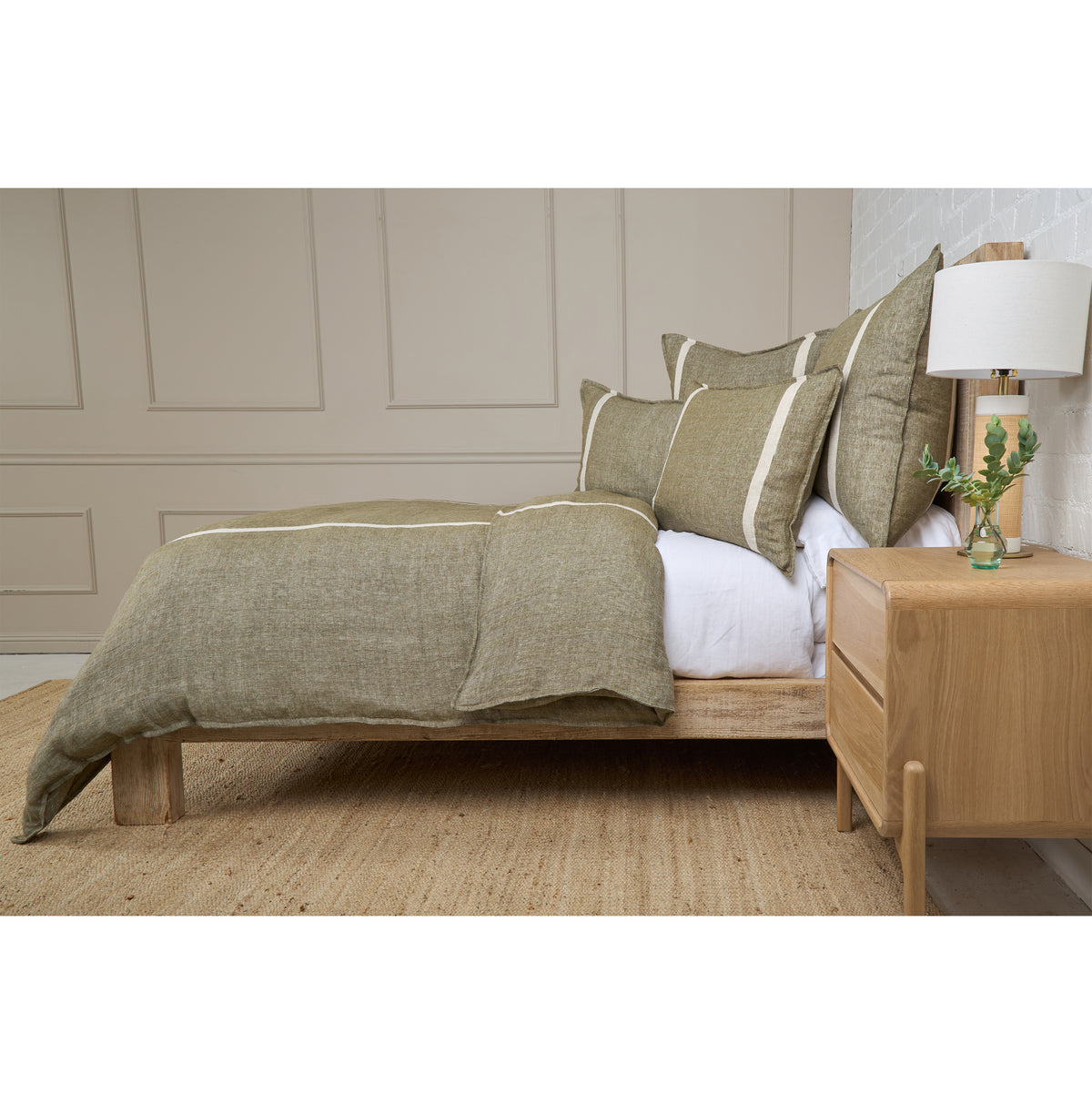 Light sage duvet cover with cream stripe trim and white pillow accents