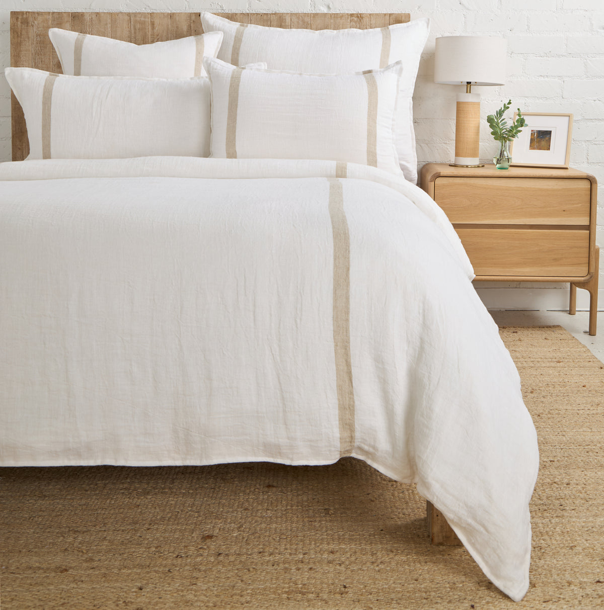 White linen-look duvet cover with thin beige stripe trim and matching pillow shams