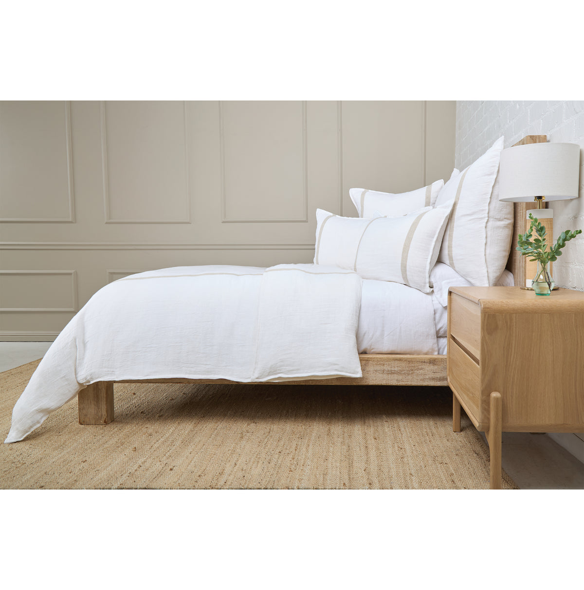 White linen-look duvet set with matching pillows and subtle stripe trim