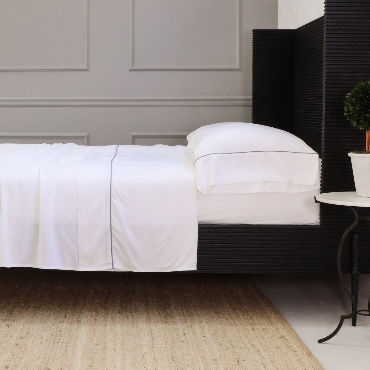 White sheet set with fitted and flat sheets, plus standard pillowcases on a bed