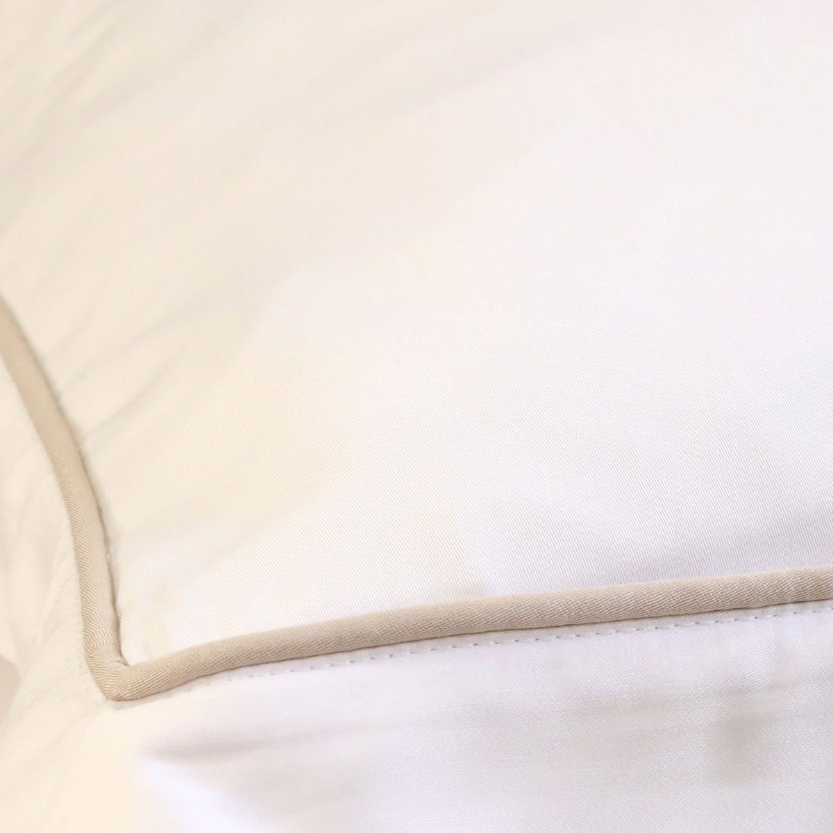 White fitted sheet corner close-up with elastic hem and stitched edge