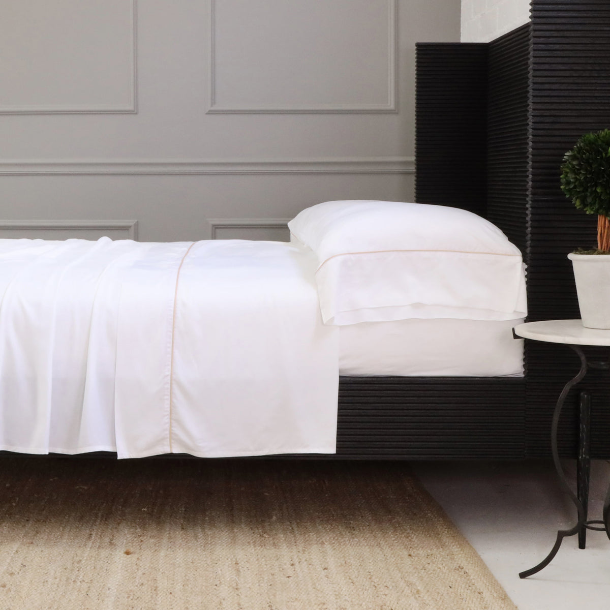 White sheet set featuring fitted sheet and pillowcases neatly arranged on bed