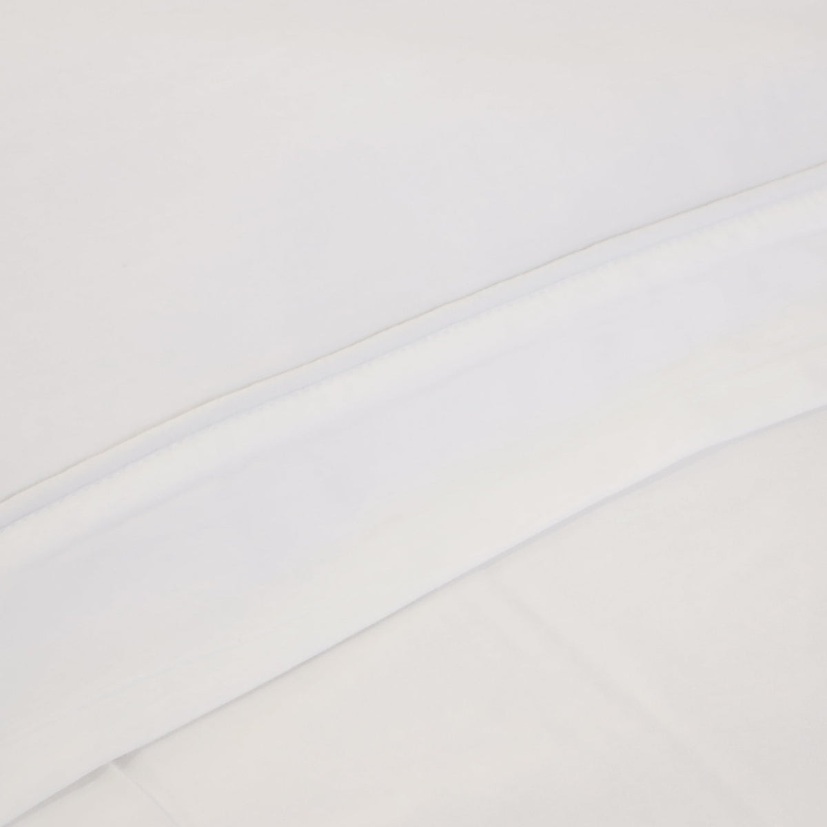 White sheet surface close-up with subtle texture and straight stitched seam
