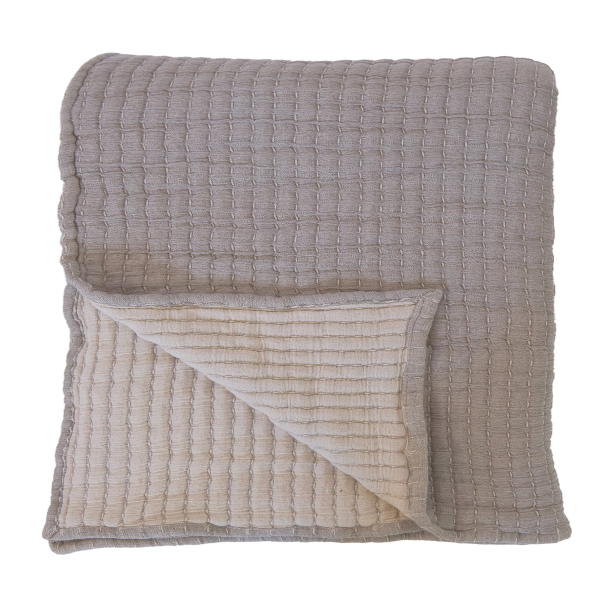 Oversized throw blanket in light grey with textured weave and cream blanket corner fold.