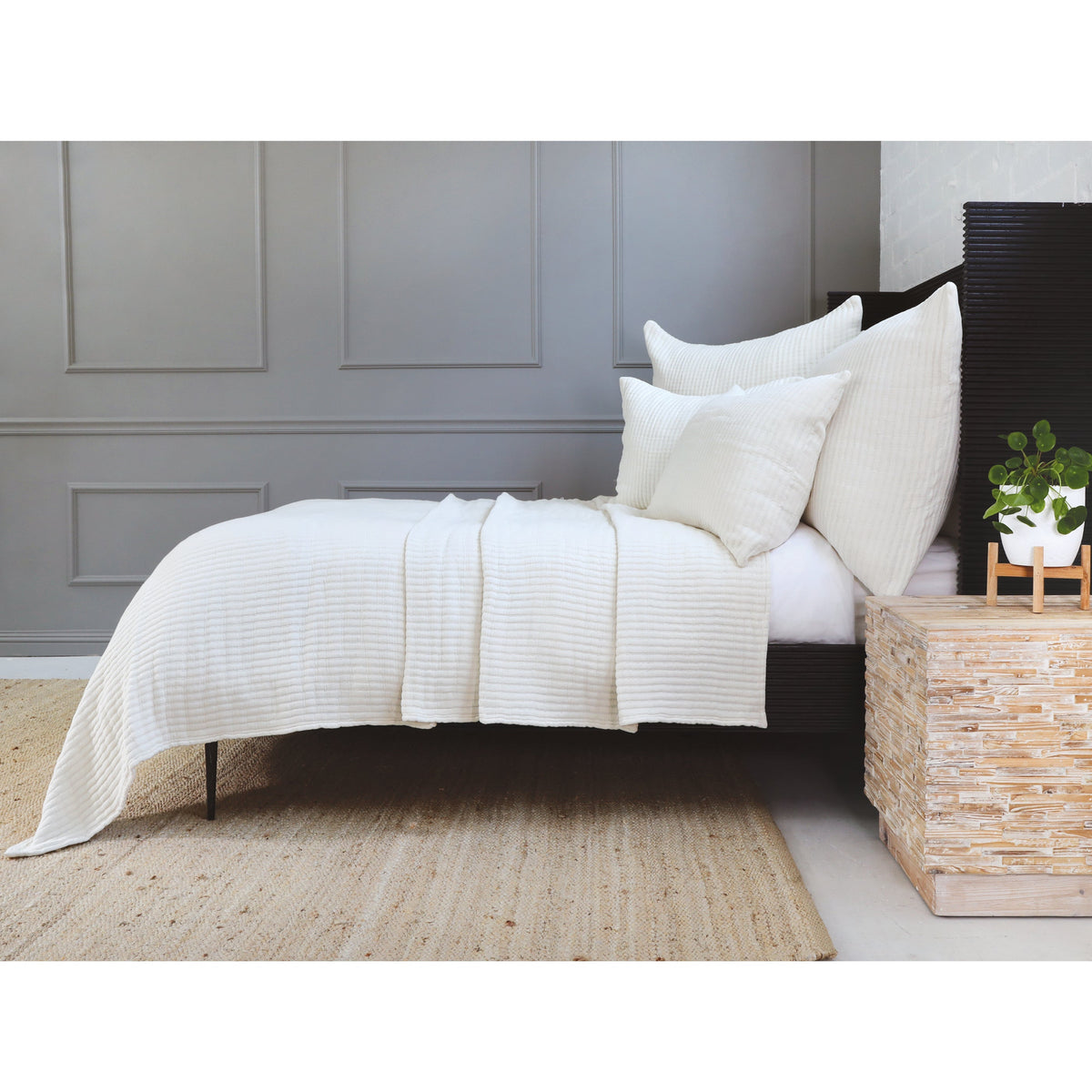 White textured coverlet set on bed with coordinated pillows