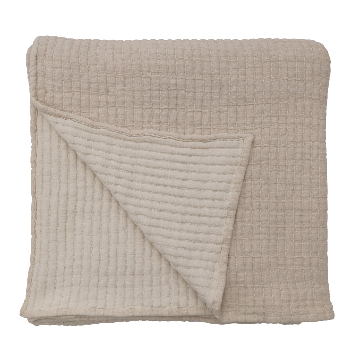 Oversized throw in cream, folded with waffle-textured stitched pattern