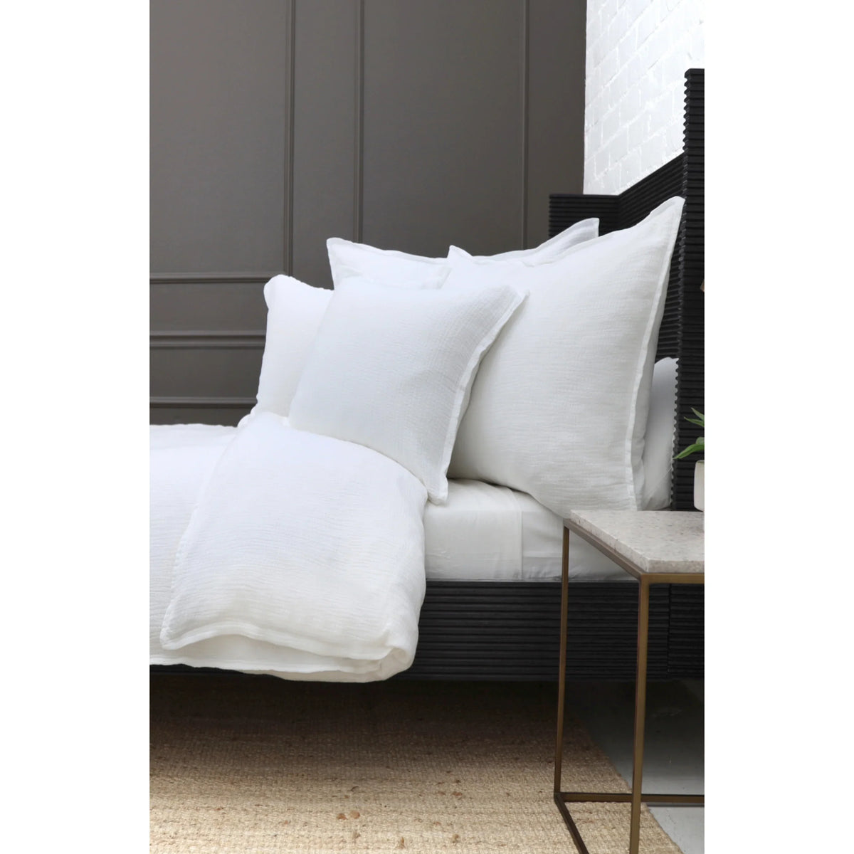 Rectangular throw pillows with inserts, white cover on bed near bedside table